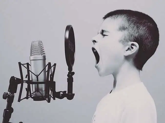 un niño cantando en un micrófono Cuándo consultar con un logopeda