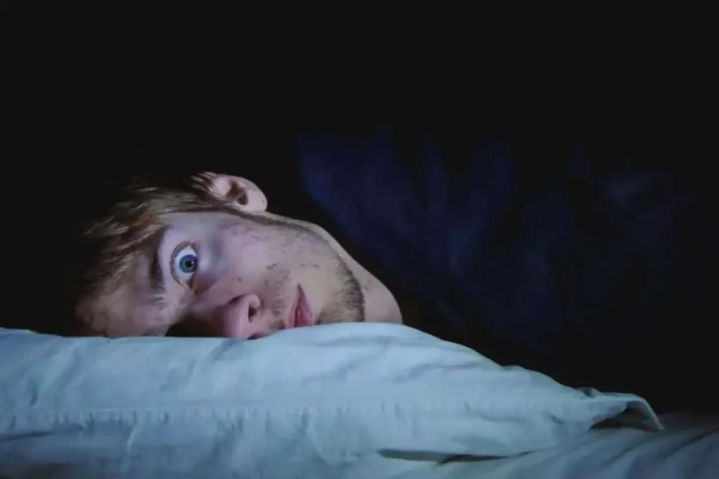 un hombre acostado sobre una almohada teniendo pesadillas