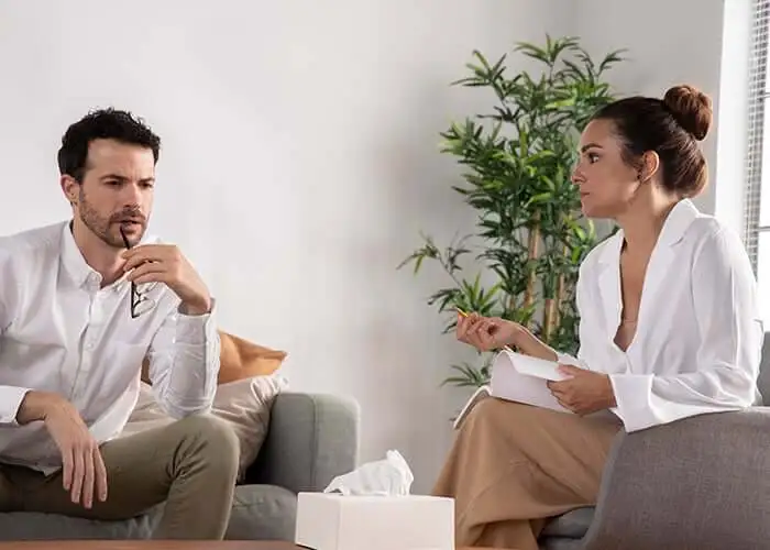 Dos personas adultas conversando en un espacio de atención profesional